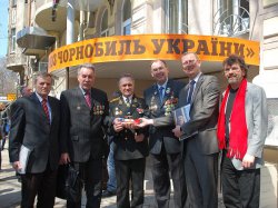 René Röspel und Oliver Kaczmarek (von rechts) überreichen ein Geschenk an ukrainische Liquidatoren vor der neu eröffneten Geschichtswerkstatt in Charkow